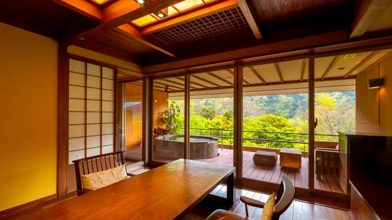 Traditional Japanese suite featuring a private open-air stone onsen with panoramic views of the lush Hakone mountains