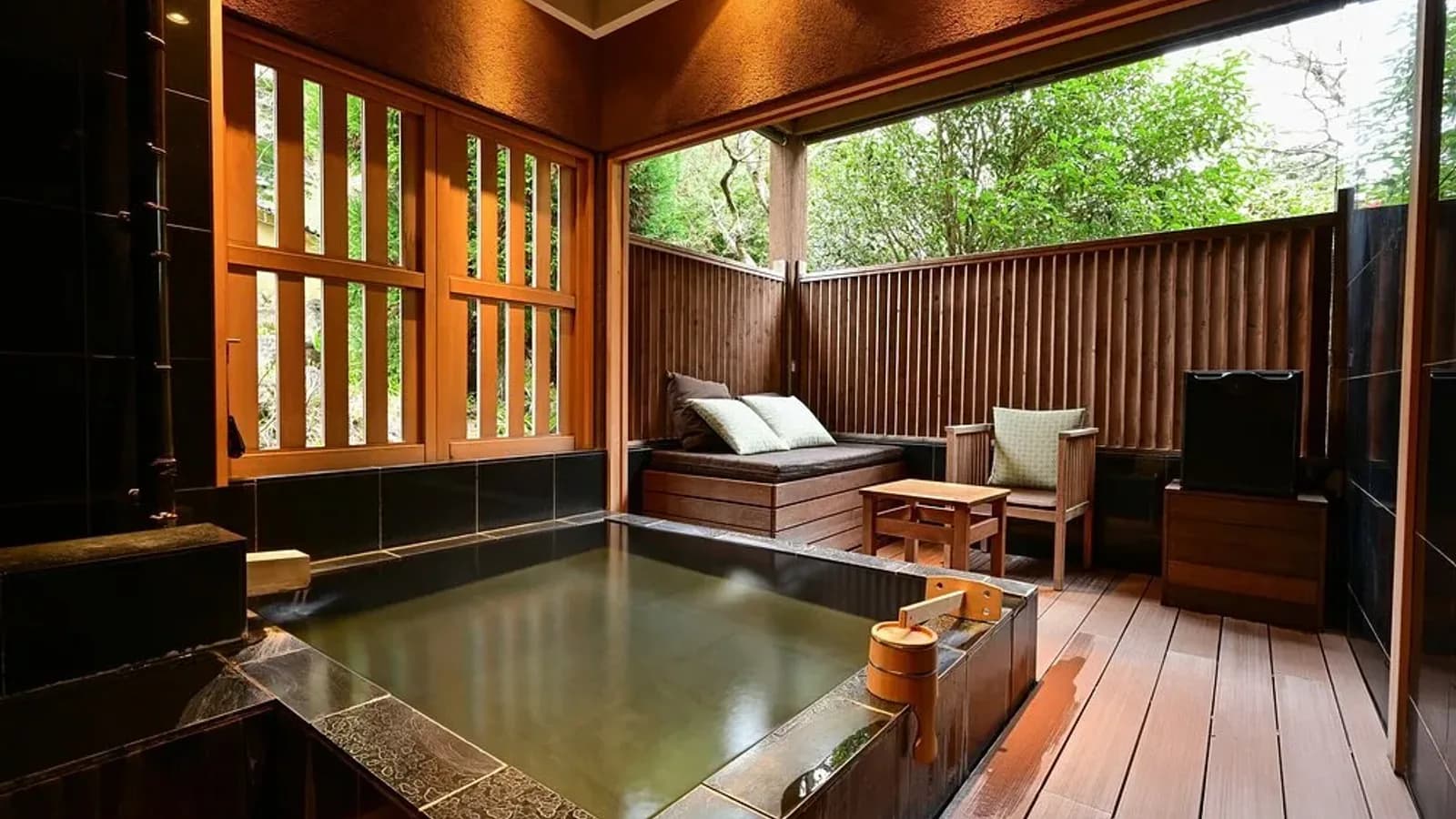 A woodland ryokan retreat in Hakone's Sengokuhara, with timber walkways and a private open-air onsen framed by cedar forest.